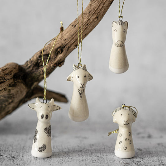 Christmas tree farm animals decoration set of four. Cow, sheep, goat, horse ceramic ornaments hanging from a gold string.