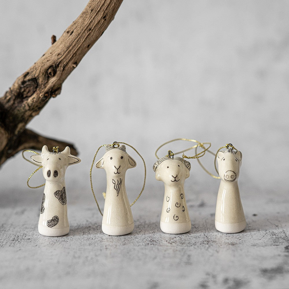 Christmas tree farm animals decoration set of four. Cow, sheep, goat, horse ceramic ornaments hanging from a gold string.