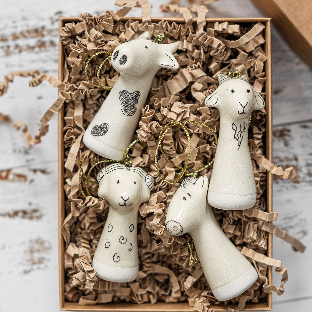 Christmas tree farm animals decoration set of four. Cow, sheep, goat, horse ceramic ornaments hanging from a gold string.