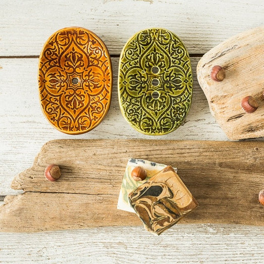 Handmade ceramic oval soap dish. Crafted from white clay and finished with a glossy brown or green glaze. Designed with drainage holes, a concave shape, and four little feet.