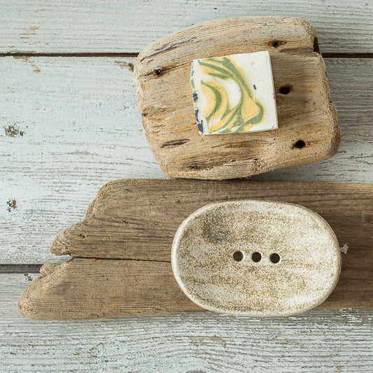 Handmade ceramic soap dish. Crafted from white clay and finished with a mat dotted glaze. Designed with drainage holes, a concave shape, and four little feet.