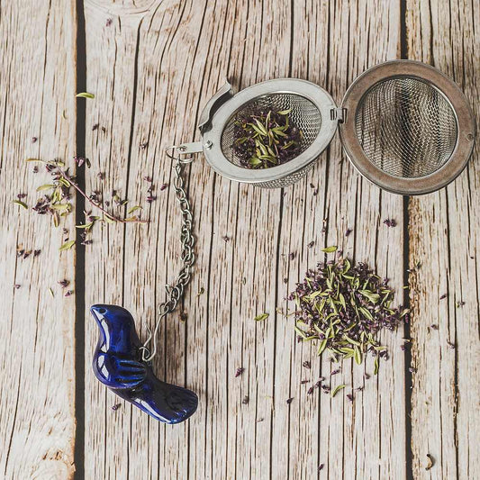 Tea infuser with ceramic blue bird hanging from the chain.