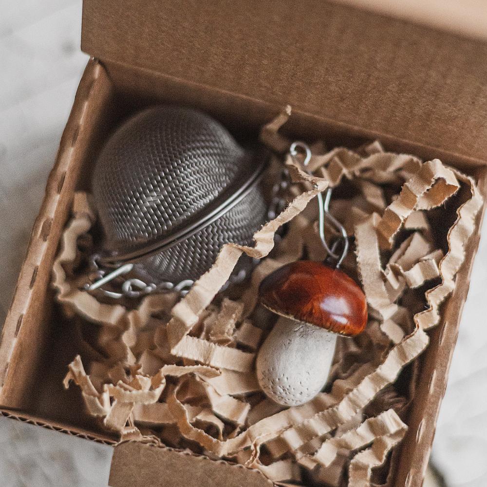 Tea infuser with ceramic boletus mushroom hanging from the chain. Packed in a paper gift box.