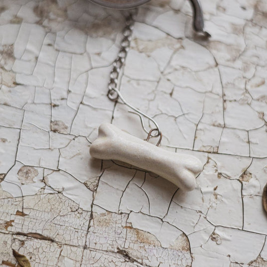 Tea infuser with white ceramic bone hanging from the chain