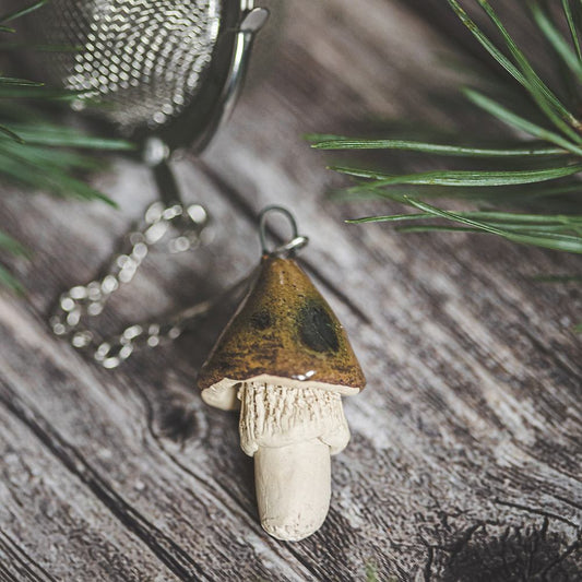 Tea infuser with ceramic brown mushroom hanging from the chain.