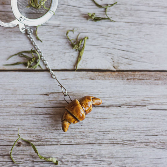Tea infuser with ceramic croissant hanging from the chain