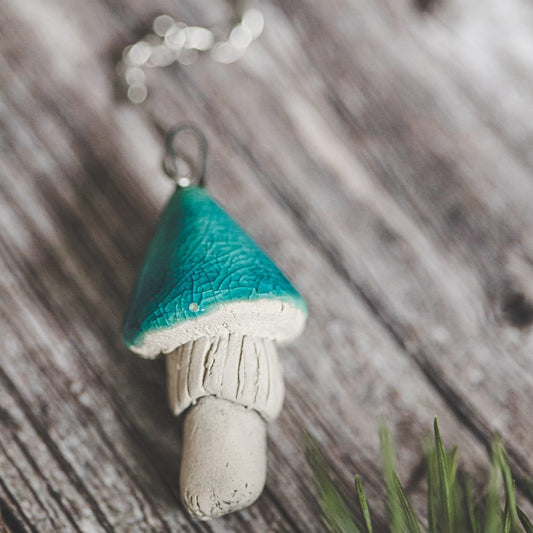 Tea infuser with ceramic light blue mushroom hanging from the chain.
