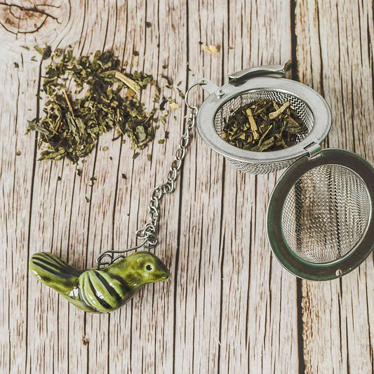 Tea infuser with ceramic moss green bird hanging from the chain.
