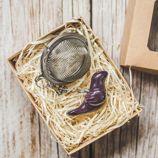 Tea infuser with ceramic purple bird hanging from the chain. Packed in a paper gift box.