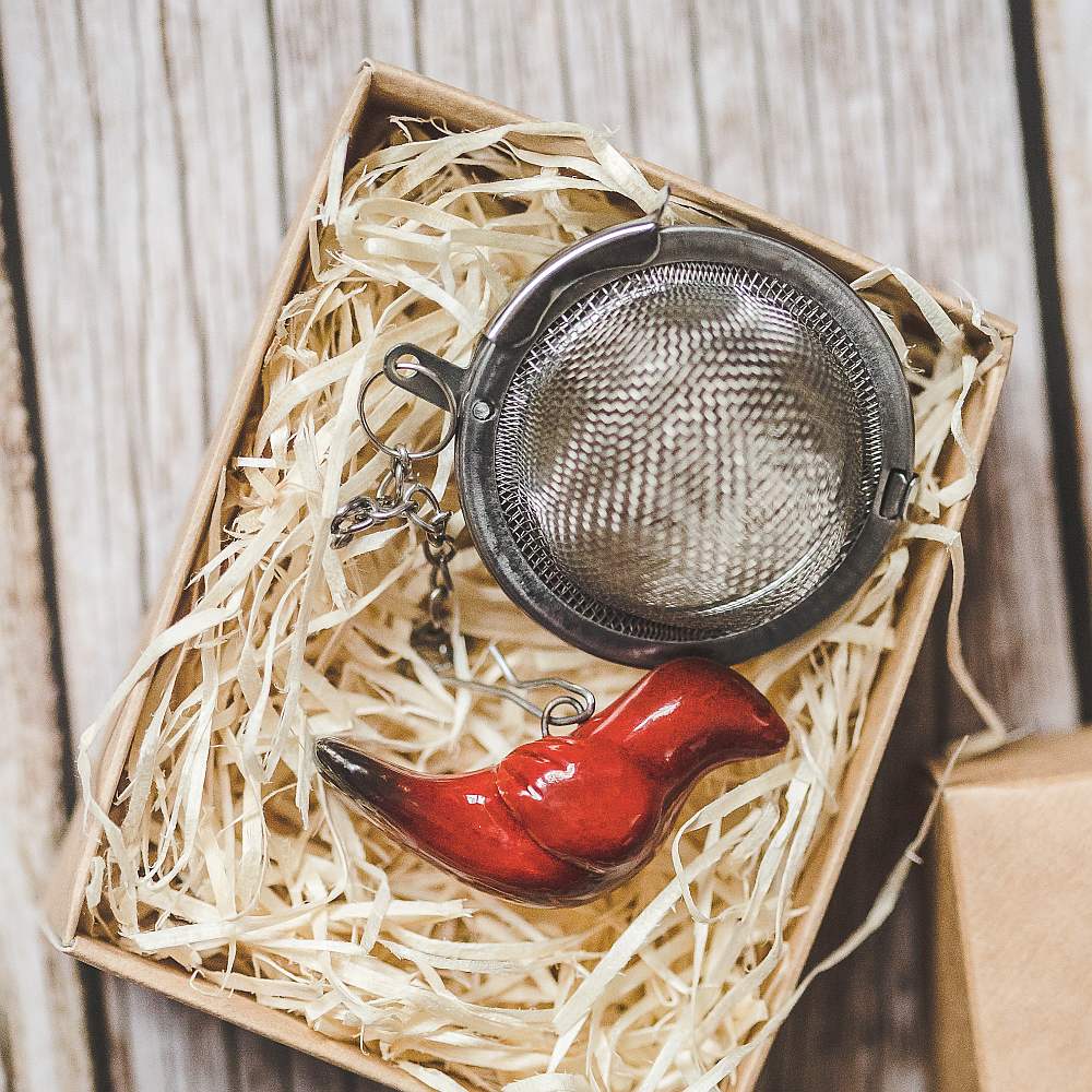 Tea infuser with ceramic red bird hanging from the chain. Packed in a paper gift box.