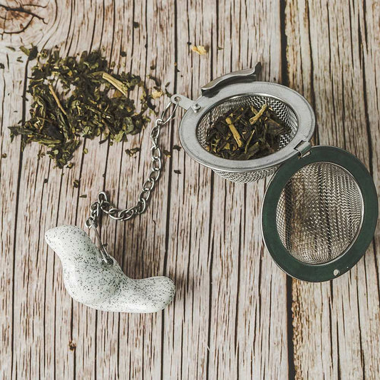 Tea infuser with ceramic white bird hanging from the chain.