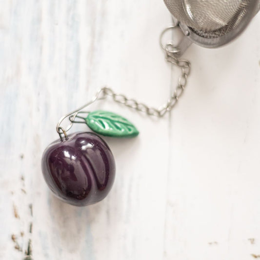 tea infuser with ceramic purple plum hanging from the chain
