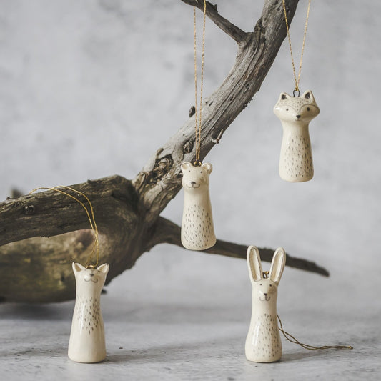 Christmas tree wild animals decoration set of four. Fox, bear, raccoon, hare ceramic ornaments hanging from a gold string.