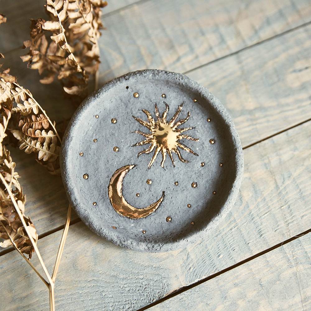 Handmade ceramic incense holder featuring gold plated moon and sun. Crafted from black grogged clay.