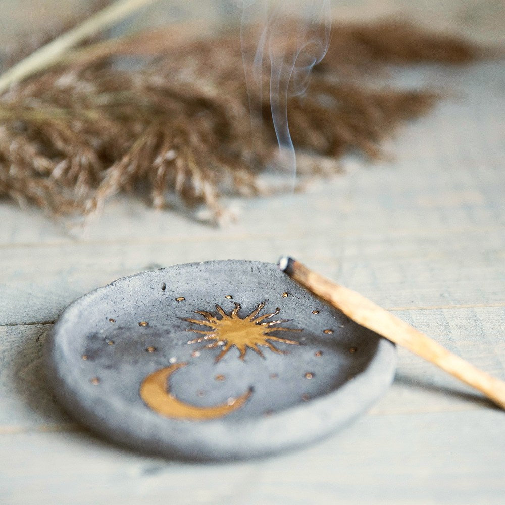 Handmade ceramic incense holder featuring gold plated moon and sun. Crafted from black grogged clay.