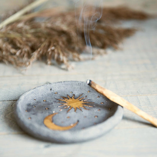 Handmade ceramic incense holder featuring gold plated moon and sun. Crafted from black grogged clay.