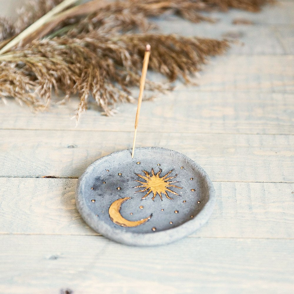 Handmade ceramic incense holder featuring gold plated moon and sun. Crafted from black grogged clay.