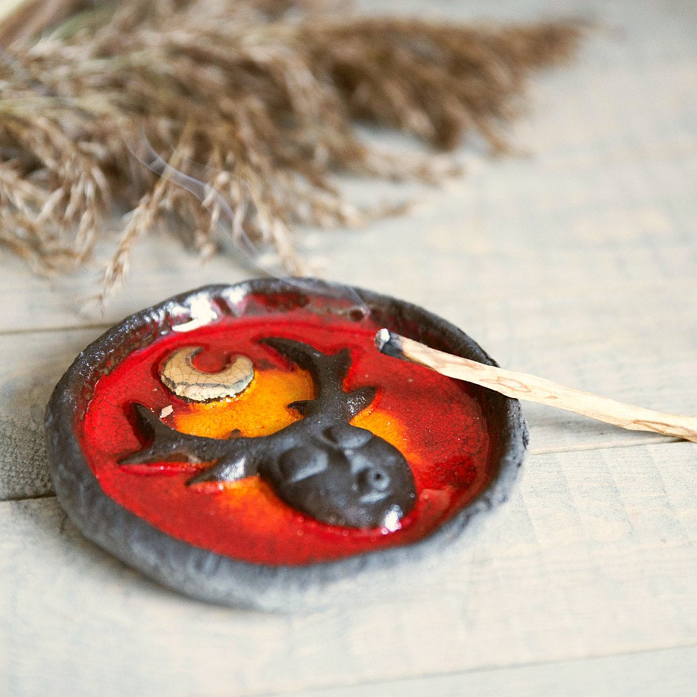 Handmade ceramic incense holder featuring mystic creature and gold plated moon design. Crafted from black grogged clay and covered with red glaze.