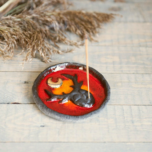 Handmade ceramic incense holder featuring mystic creature and gold plated moon design. Crafted from black grogged clay and covered with red glaze.