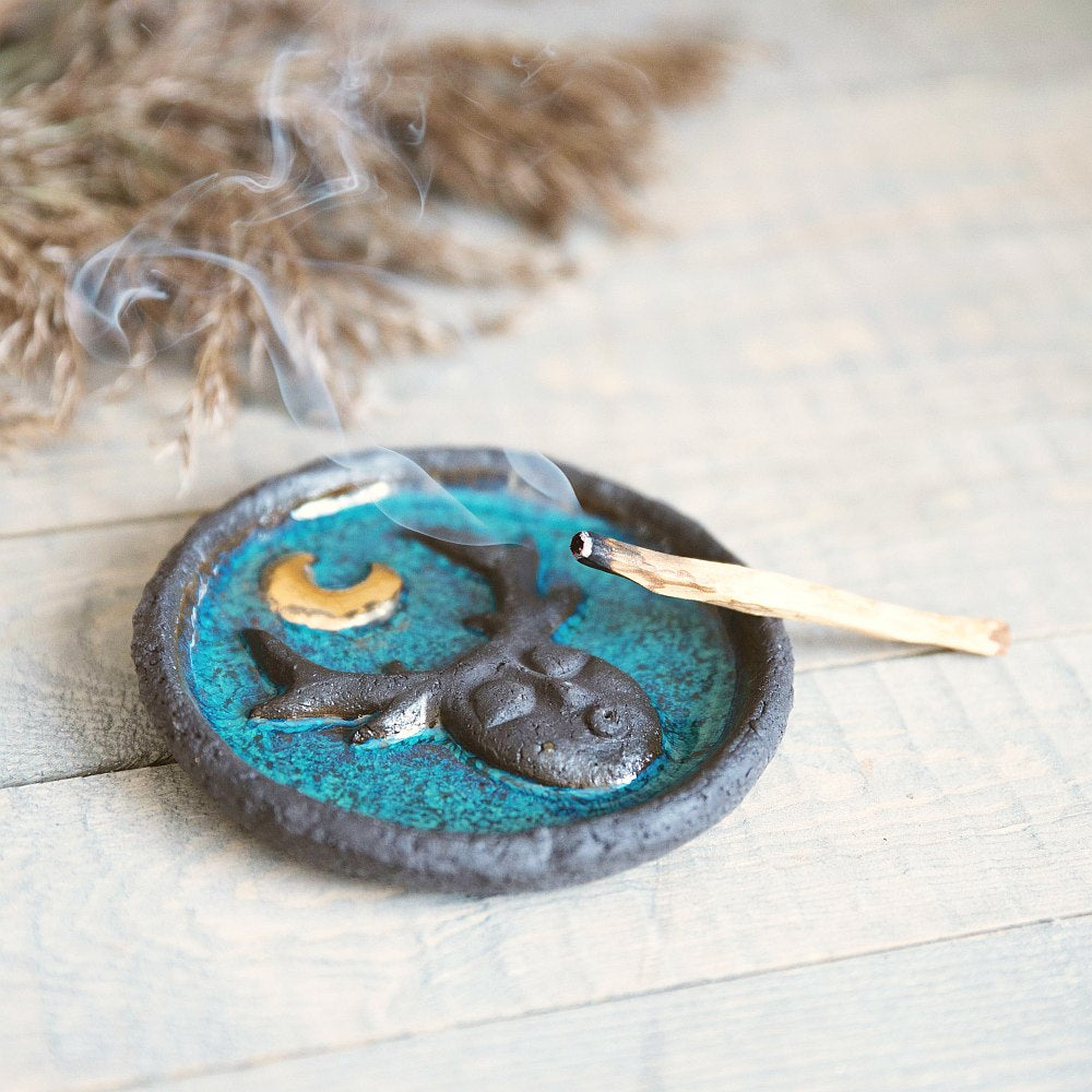 Handmade ceramic incense holder featuring mystic creature and gold plated moon design. Crafted from black grogged clay and covered with blue glaze.
