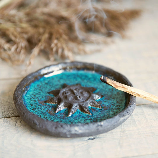 Handmade ceramic incense holder featuring the sun design. Crafted from black grogged clay and covered with blue glaze.