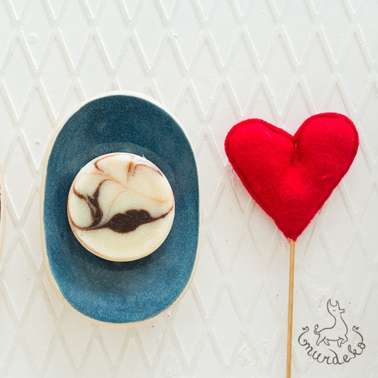 Handmade ceramic soap dish. Crafted from white clay and finished with a glossy blue glaze. Designed with drainage holes, a concave shape, and four little feet.