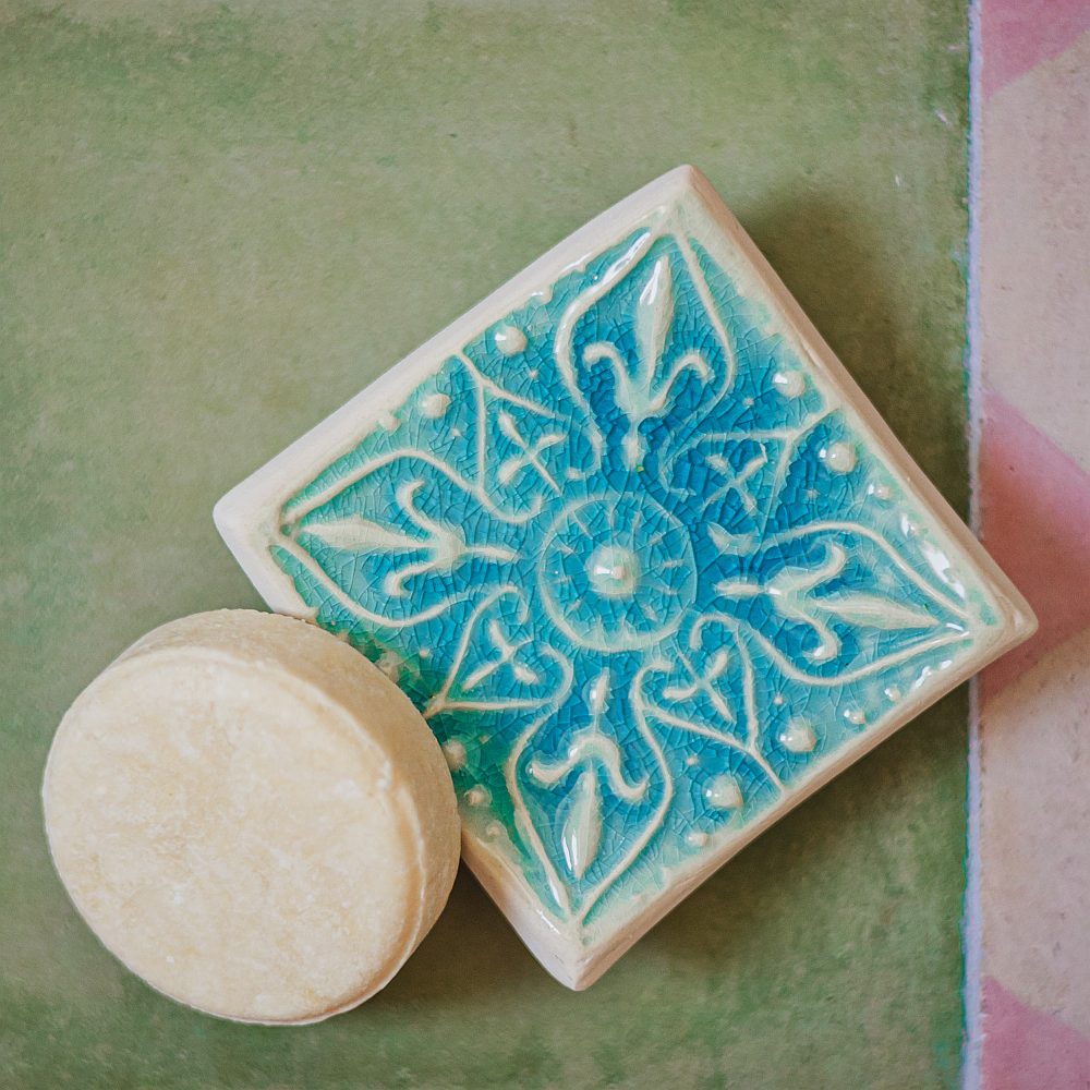 Handmade ceramic square soap dish. Crafted from white clay and finished with a glossy blue glaze. Designed with drainage holes, a concave shape, and four little feet.