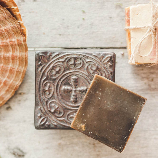 Handmade ceramic square soap dish. Crafted from white clay and finished with a matt brown glaze. Designed with drainage holes, a concave shape, and four little feet.