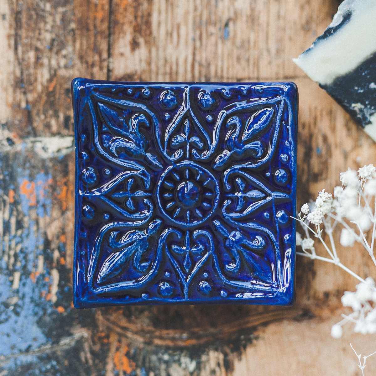 Handmade ceramic square soap dish. Crafted from white clay and finished with a glossy dark blue glaze. Designed with drainage holes, a concave shape, and four little feet.