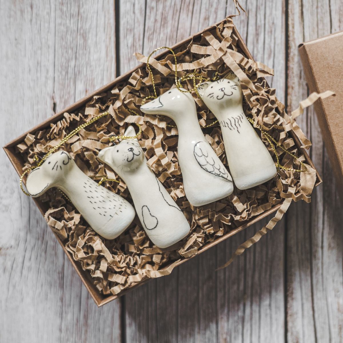 Christmas tree domestic animals decoration set of four. Dog, cat, mouse and duck ceramic ornaments hanging from a gold string.