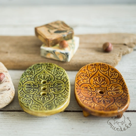 Handmade ceramic oval soap dish. Crafted from white clay and finished with a glossy brown or green glaze. Designed with drainage holes, a concave shape, and four little feet.