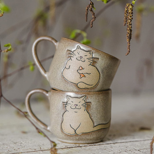 Handmade green ceramic mug with a matt glaze, featuring an unglazed cat design on the side.