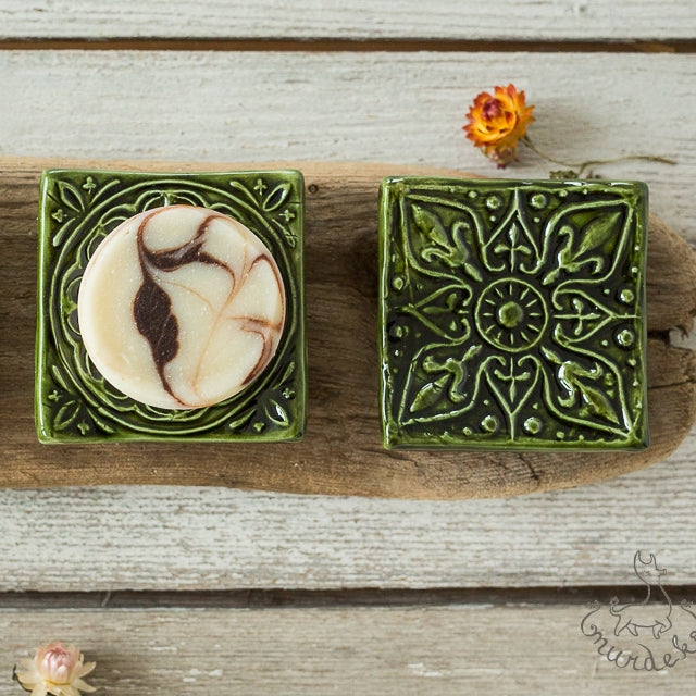 Handmade ceramic square soap dish. Crafted from white clay and finished with a glossy moss green glaze. Designed with drainage holes, a concave shape, and four little feet.