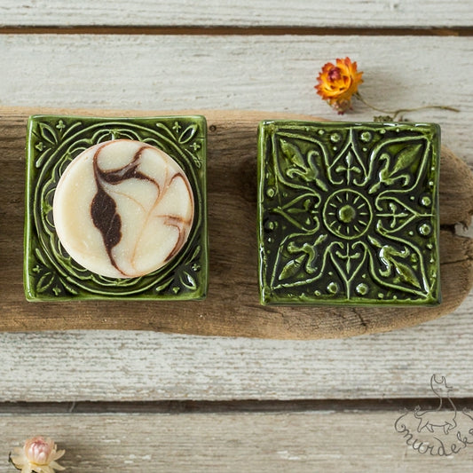 Handmade ceramic square soap dish. Crafted from white clay and finished with a glossy moss green glaze. Designed with drainage holes, a concave shape, and four little feet.