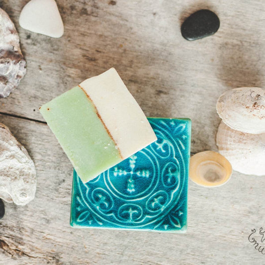 Handmade ceramic square soap dish. Crafted from white clay and finished with a glossy blue glaze. Designed with drainage holes, a concave shape, and four little feet.