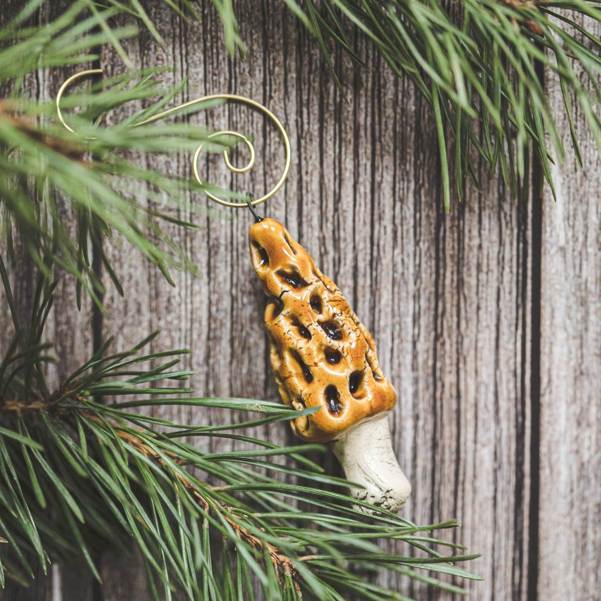 Ceramic False Morel mushroom with glossy brown cap and cream-colored stem. Handmade Christmas tree ornament with hook.