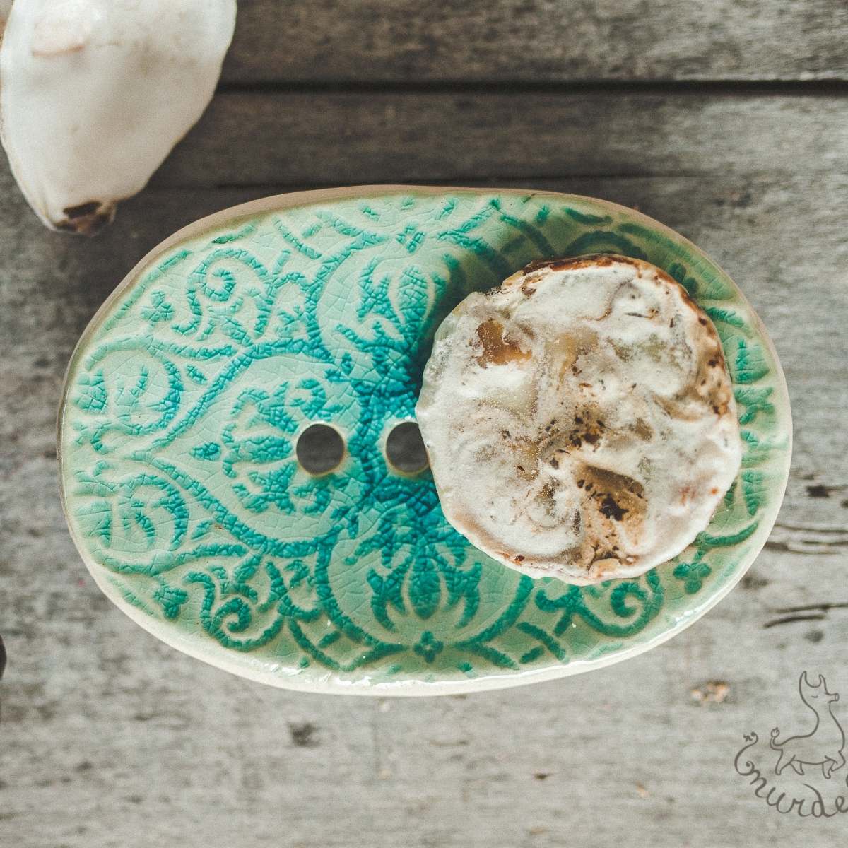 Handmade ceramic soap dish. Crafted from white clay and finished with a glossy light blue glaze. Designed with drainage holes, a concave shape, and four little feet.