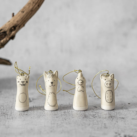 Christmas tree ranch animals decoration set of four. Beaver, llama, rooster, pig ceramic ornaments hanging from a gold string.