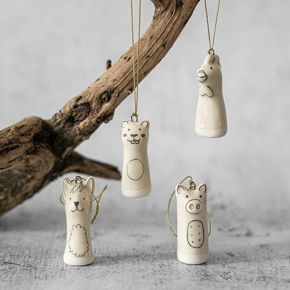 Christmas tree ranch animals decoration set of four. Beaver, llama, rooster, pig ceramic ornaments hanging from a gold string.