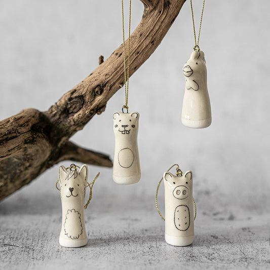 Christmas tree ranch animals decoration set of four. Beaver, llama, rooster, pig ceramic ornaments hanging from a gold string.