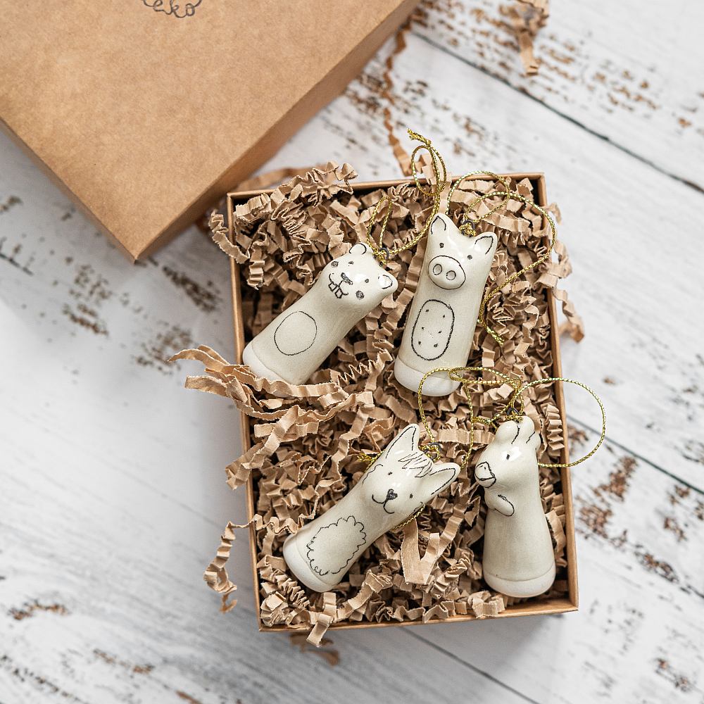 Christmas tree ranch animals decoration set of four. Beaver, llama, rooster, pig ceramic ornaments hanging from a gold string.