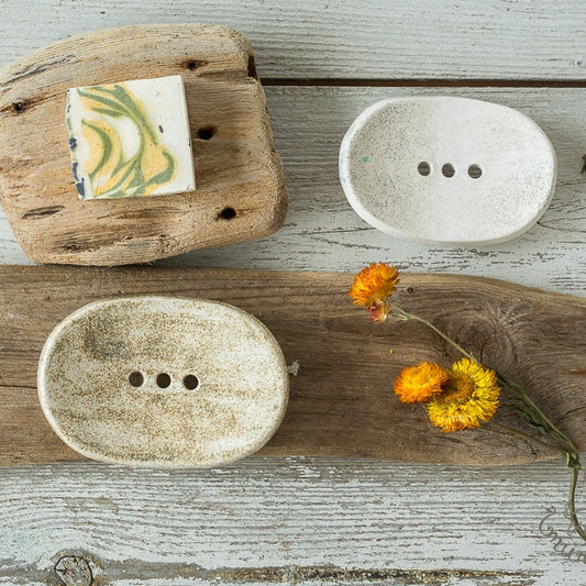 Handmade ceramic soap dish. Crafted from white clay and finished with a mat dotted glaze. Designed with drainage holes, a concave shape, and four little feet.