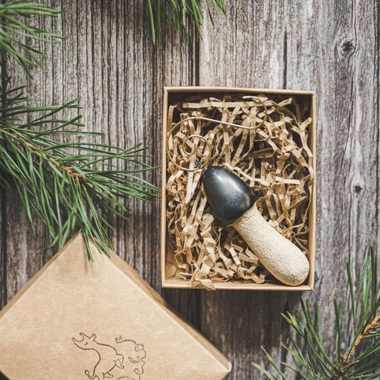 Ceramic stinkhorn mushroom with mat black cap and cream-colored stem. Handmade Christmas tree ornament with hook.