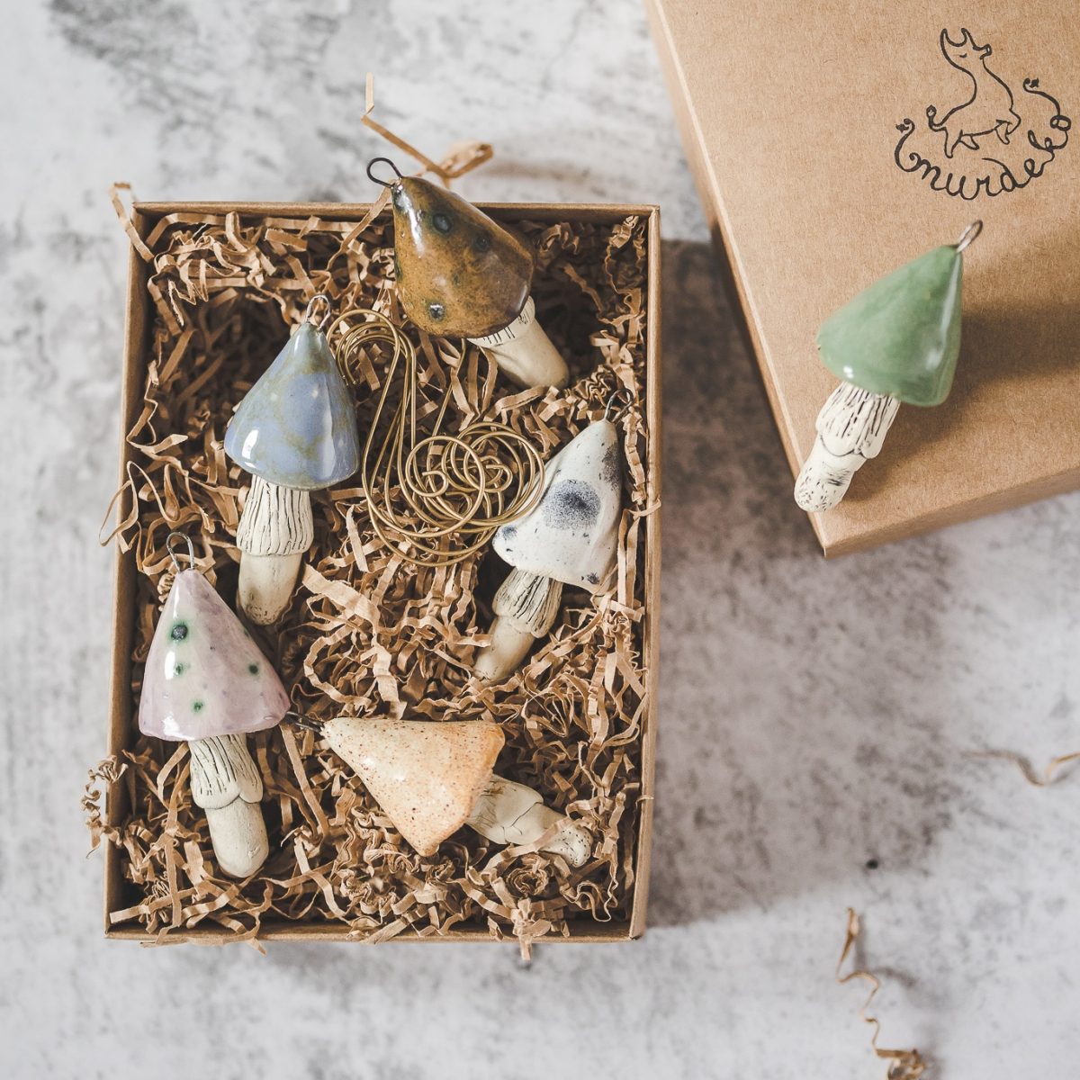 Christmas ornament set of six pastel blue, purple, brown, yellow, white and green mushrooms. Packed in a gift box with hooks.