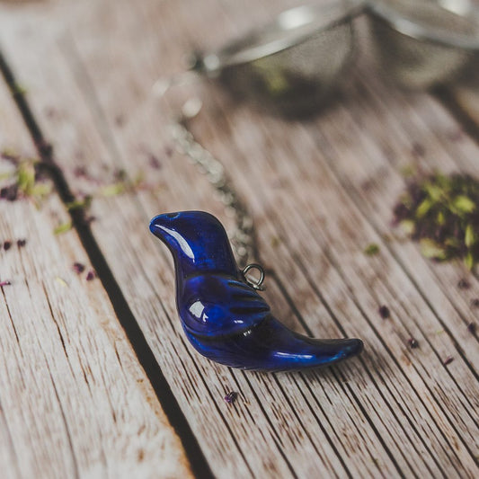 Tea infuser with ceramic blue bird hanging from the chain.