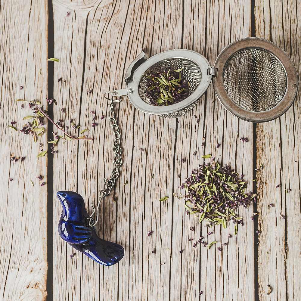 Tea infuser with ceramic blue bird hanging from the chain.