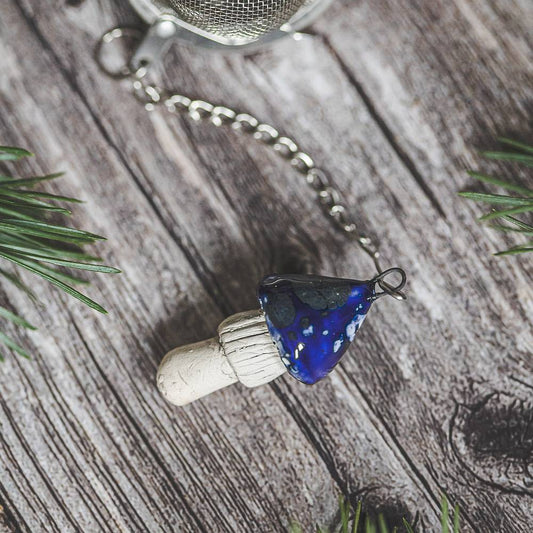 Tea infuser with ceramic blue mushroom hanging from the chain.