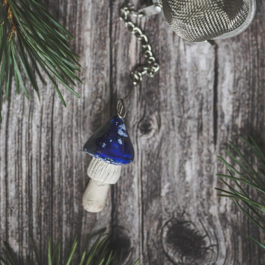 Tea infuser with ceramic blue mushroom hanging from the chain.