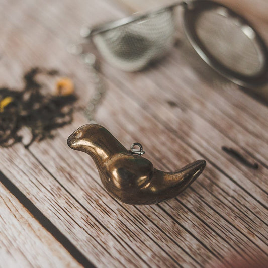 Tea infuser with ceramic bronze bird hanging from the chain.