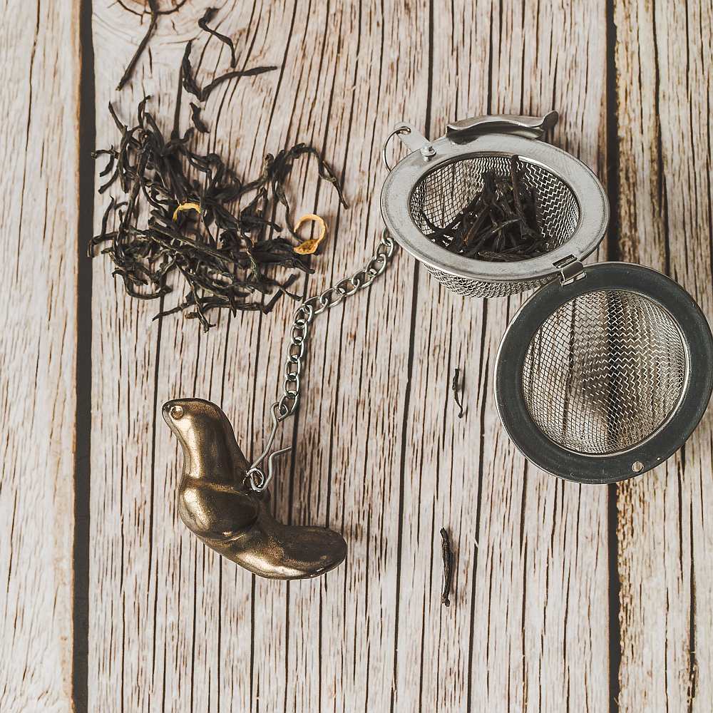 Tea infuser with ceramic bronze bird hanging from the chain.